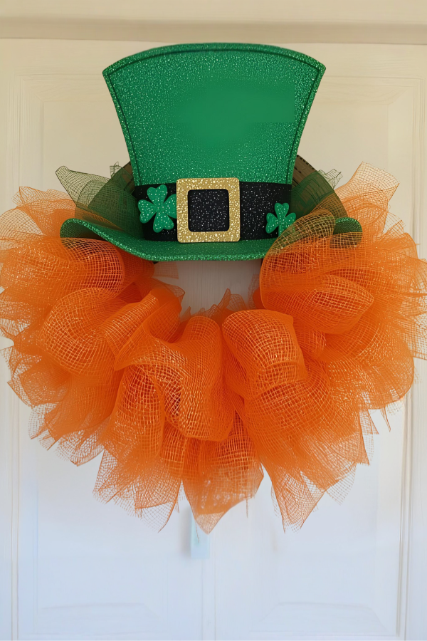 Leprechaun hat wreath with orange deco mesh hanging on a white front door