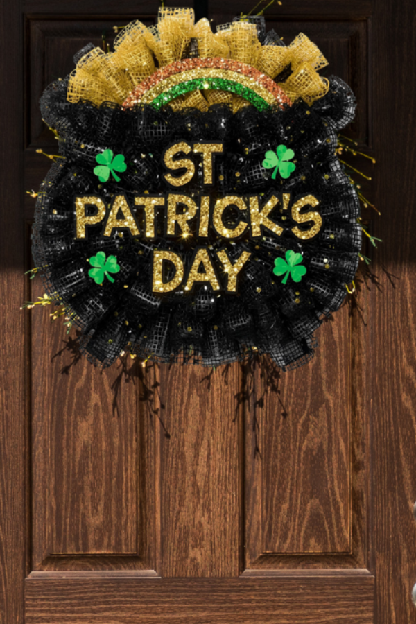 St Patrick’s Day pot of gold wreath made with black and gold deco mesh, gold glitter St Patrick’s Day text, green shamrocks, and a rainbow accent.
