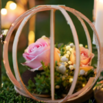 Fairytale bridal shower centerpiece with pink roses, greenery, and a delicate gold wire carriage surrounded by glowing candles