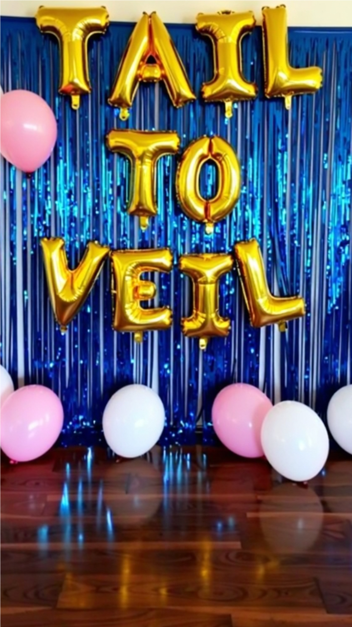 Mermaid-themed 'Tail to Veil' bridal shower backdrop with gold foil letter balloons, blue fringe curtains, and pink and white balloons on a wooden floor