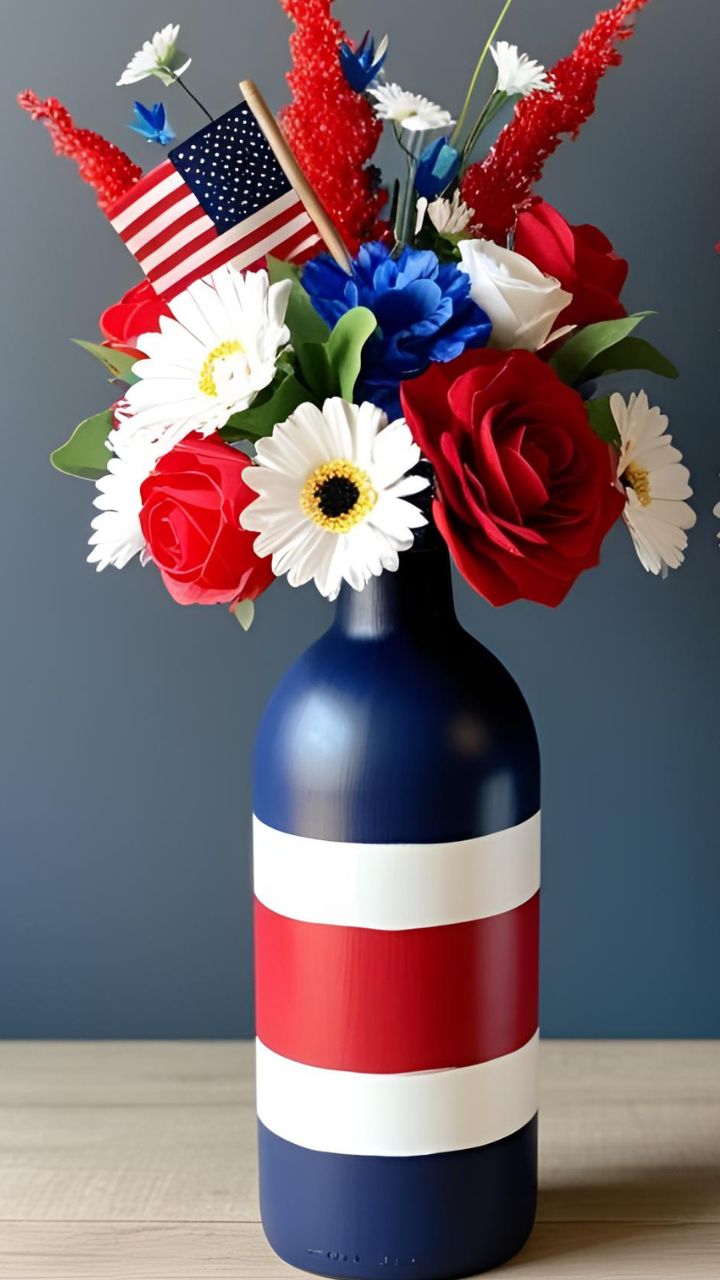 Patriotic centerpiece with red, white, and blue striped bottle vase filled with American flag and festive flowers.