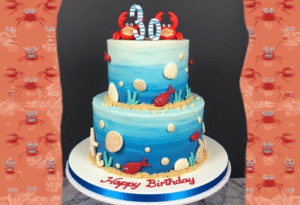 Two-tier under-the-sea themed birthday cake with crabs, seashells, and ocean creatures