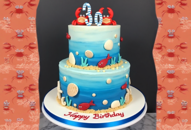 Two-tier under-the-sea themed birthday cake with crabs, seashells, and ocean creatures