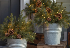Rustic winter porch decor with pinecone arrangements in galvanized buckets and warm string lights