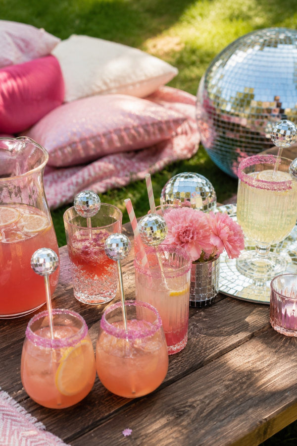 Colorful disco-themed drinks at an outdoor picnic.